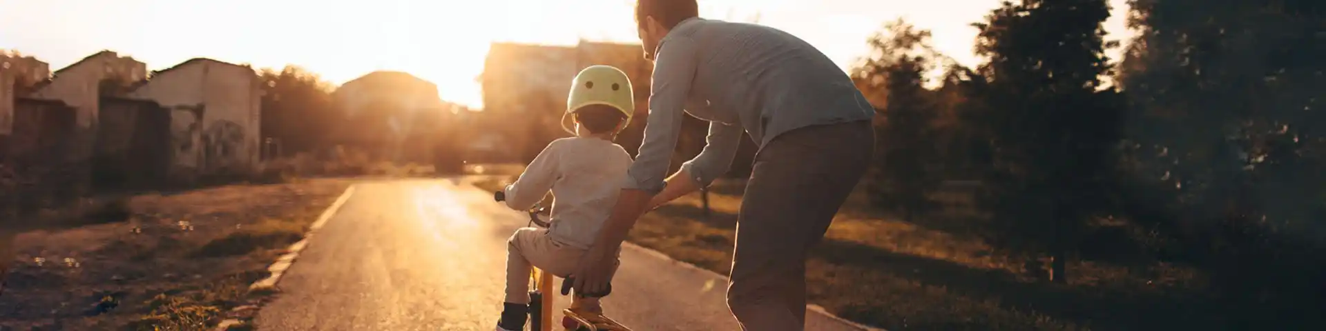 parent helping their child ride a bike