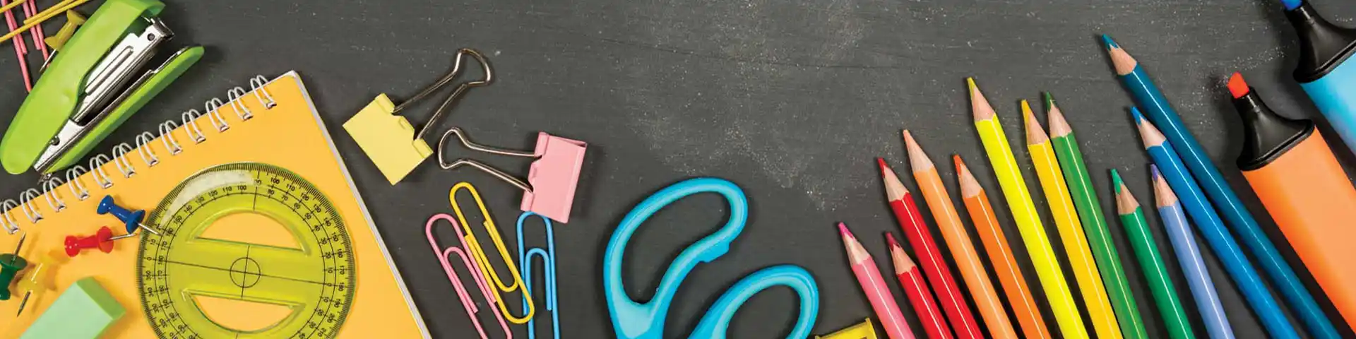 various school supplies laid out on a black desk