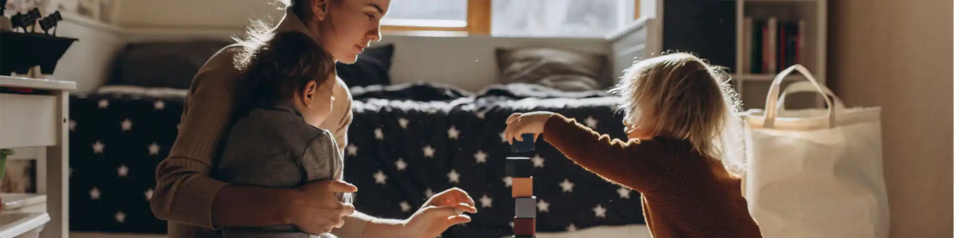 mother assisting her children during play time